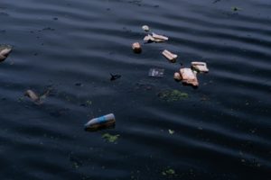 plastic bottles and wrappers in polluted water